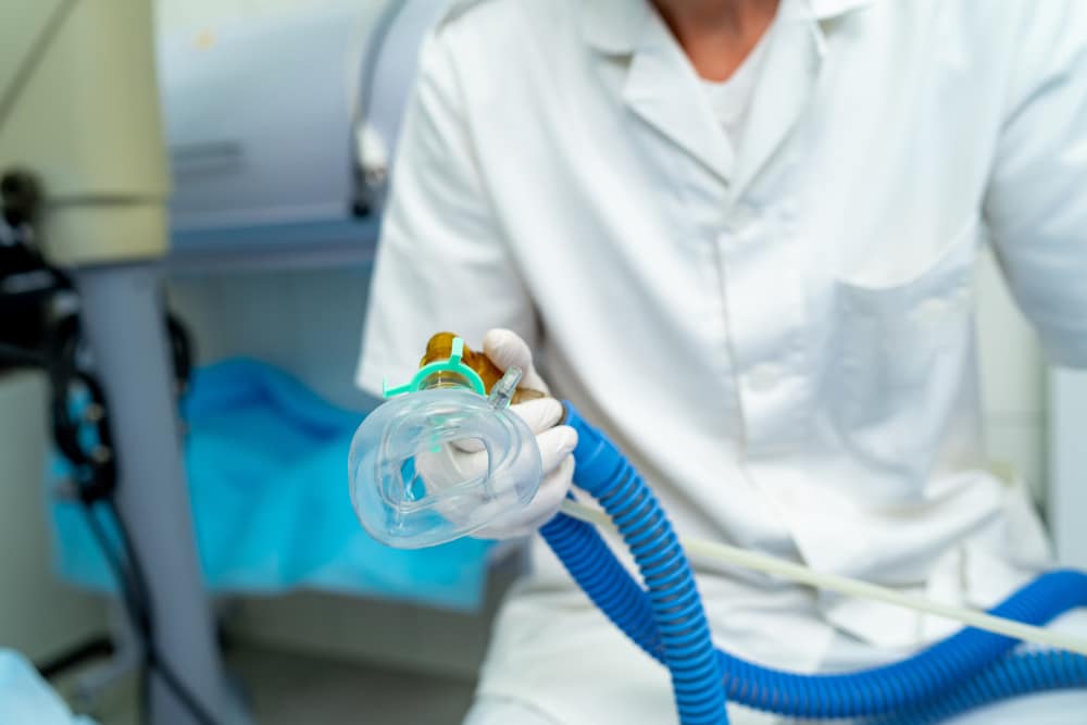 A full sedation dentist holding a mask for anesthesia