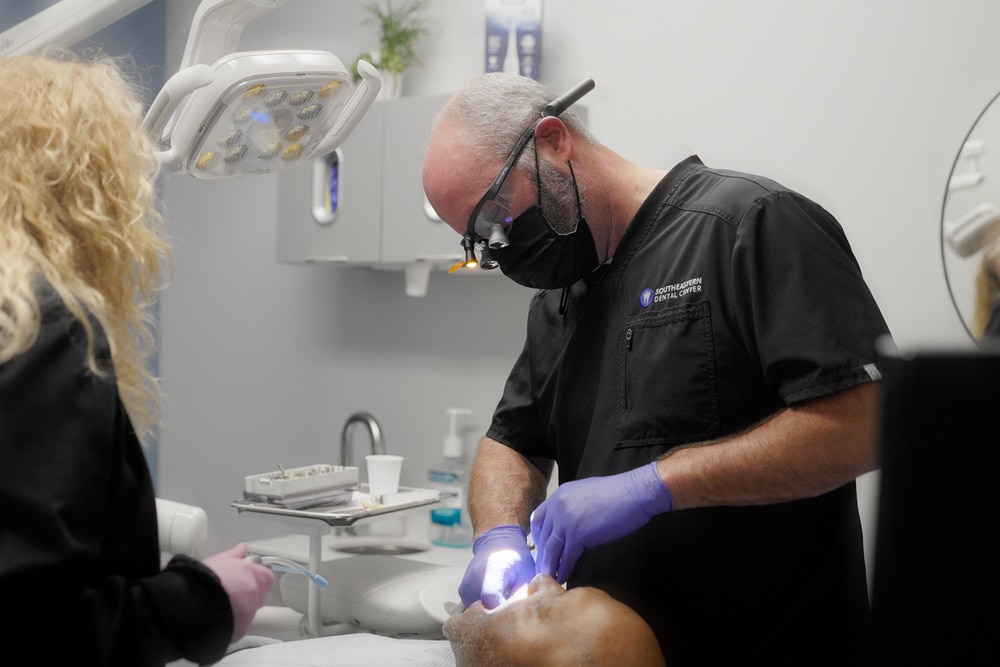 A happy female patient and a male dentist wearing a protective mask